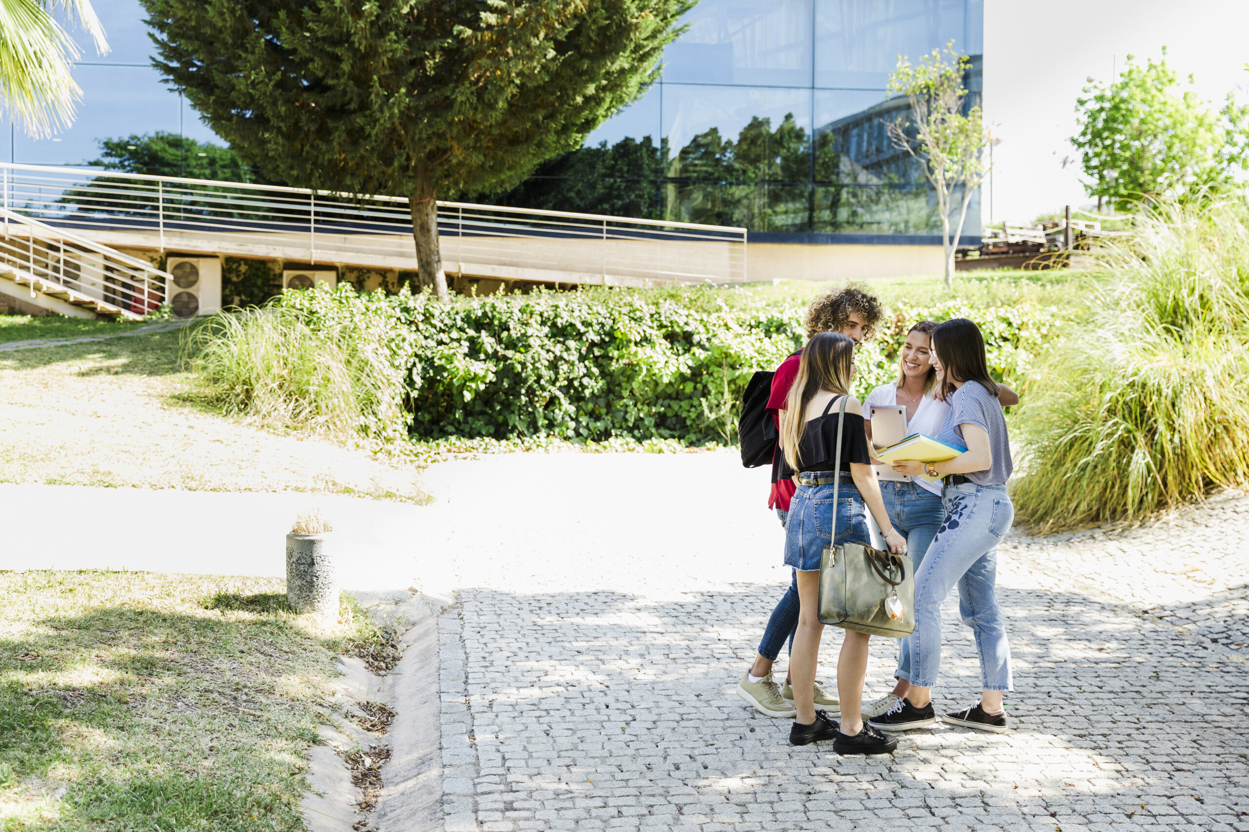 students-chatting-near-campus-building